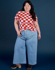 Ashley is wearing Checker Organic Tee in Red and light wash Indigo Wide Leg Trousers