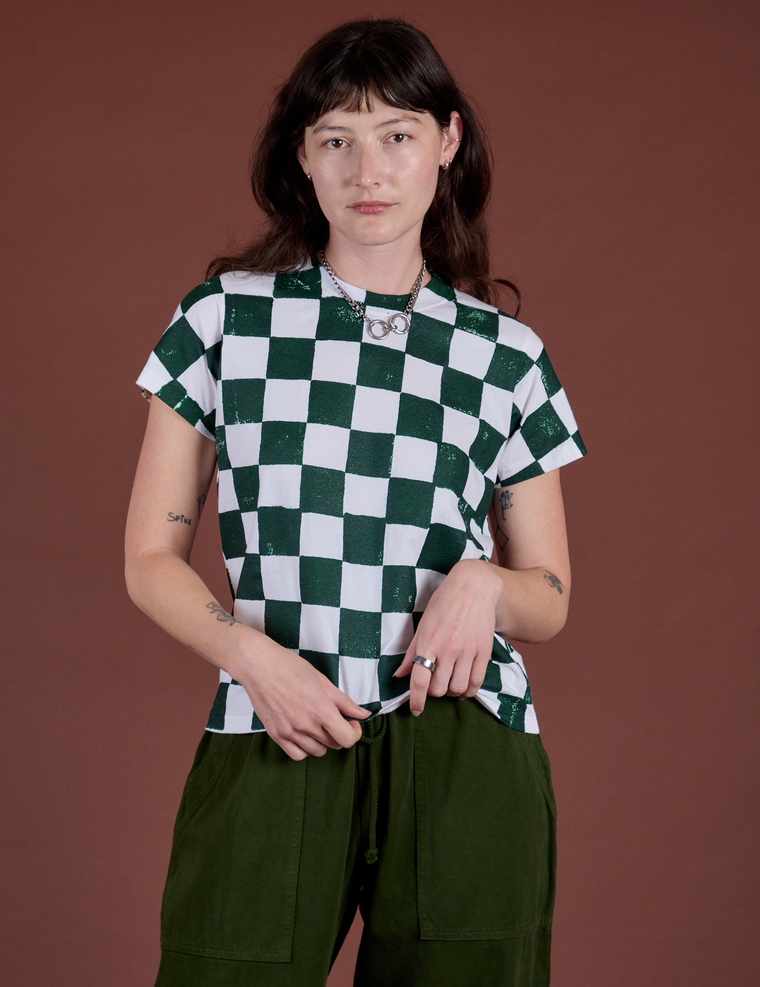 Alex is 5'8" and wearing P Checker Organic Tee in Swamp Green