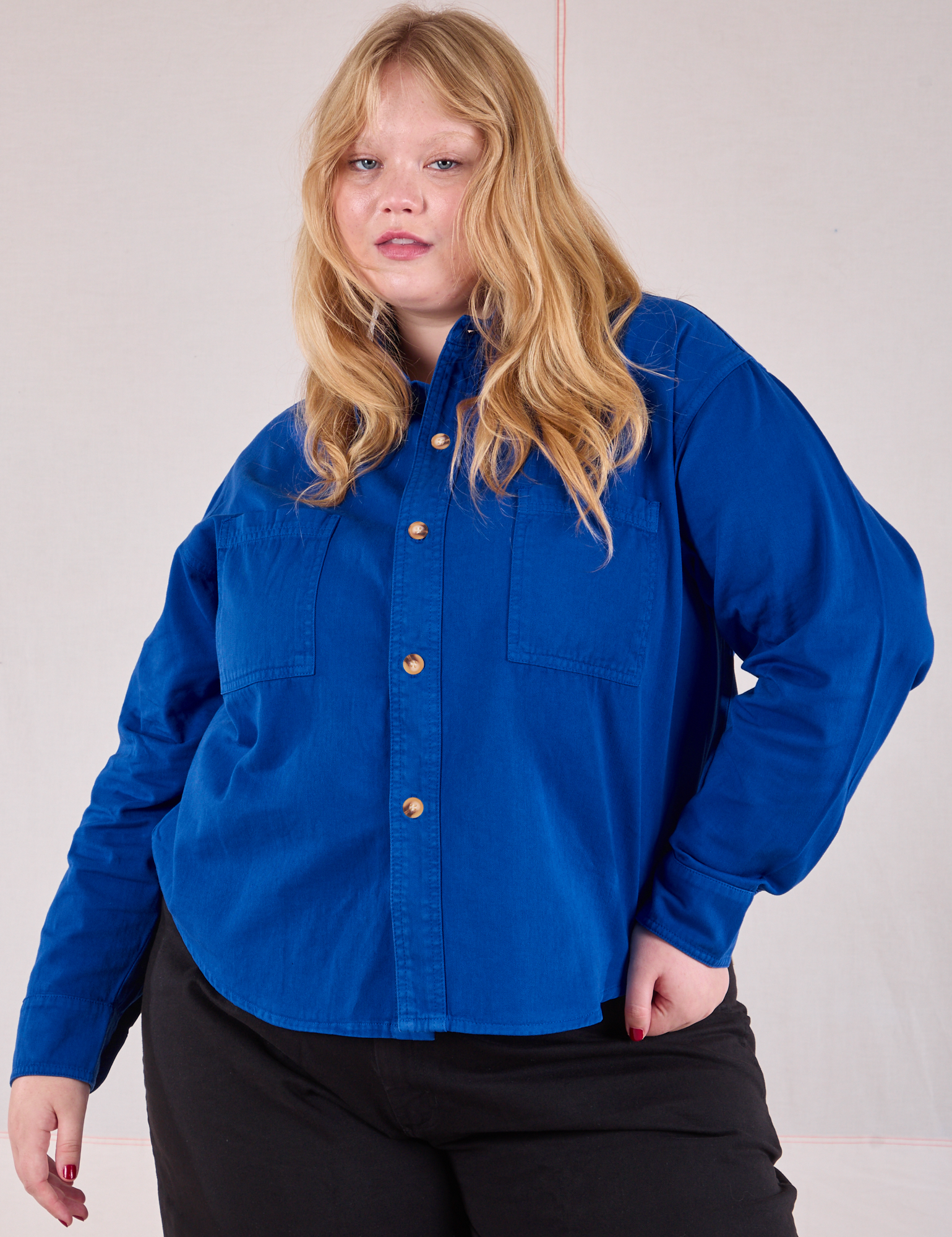 Juliet is wearing a buttoned up Cropped Overshirt in Royal Blue