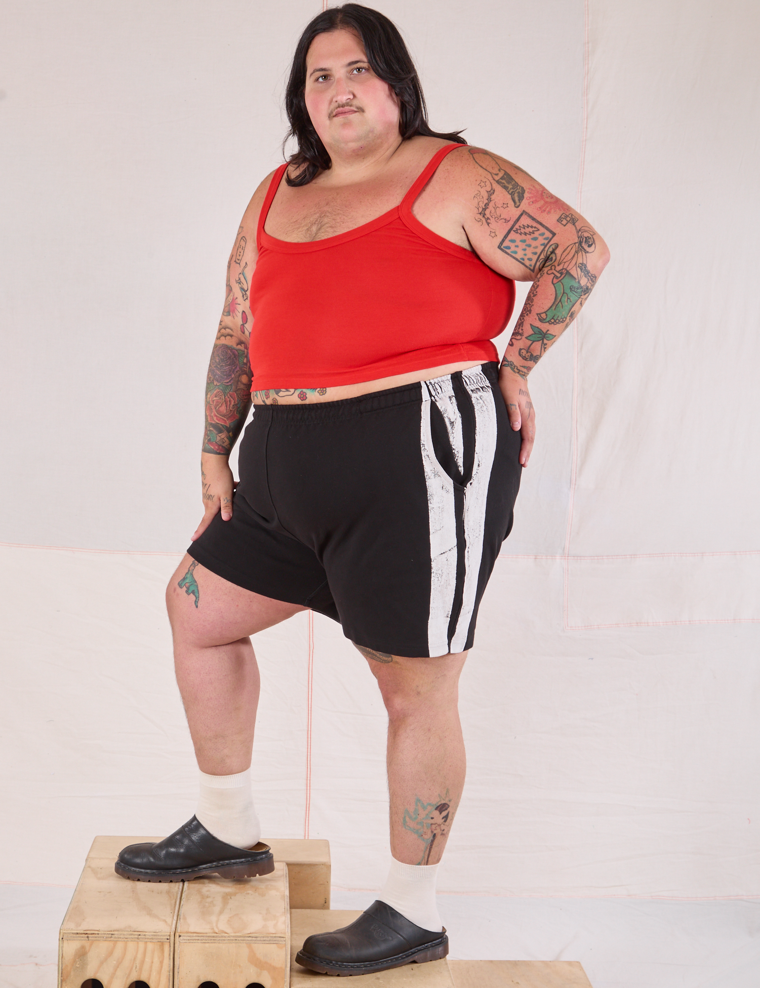 Angled front view of Painted Stripe Easy Shorts in Basic Black and mustang red Cropped Cami on Sam