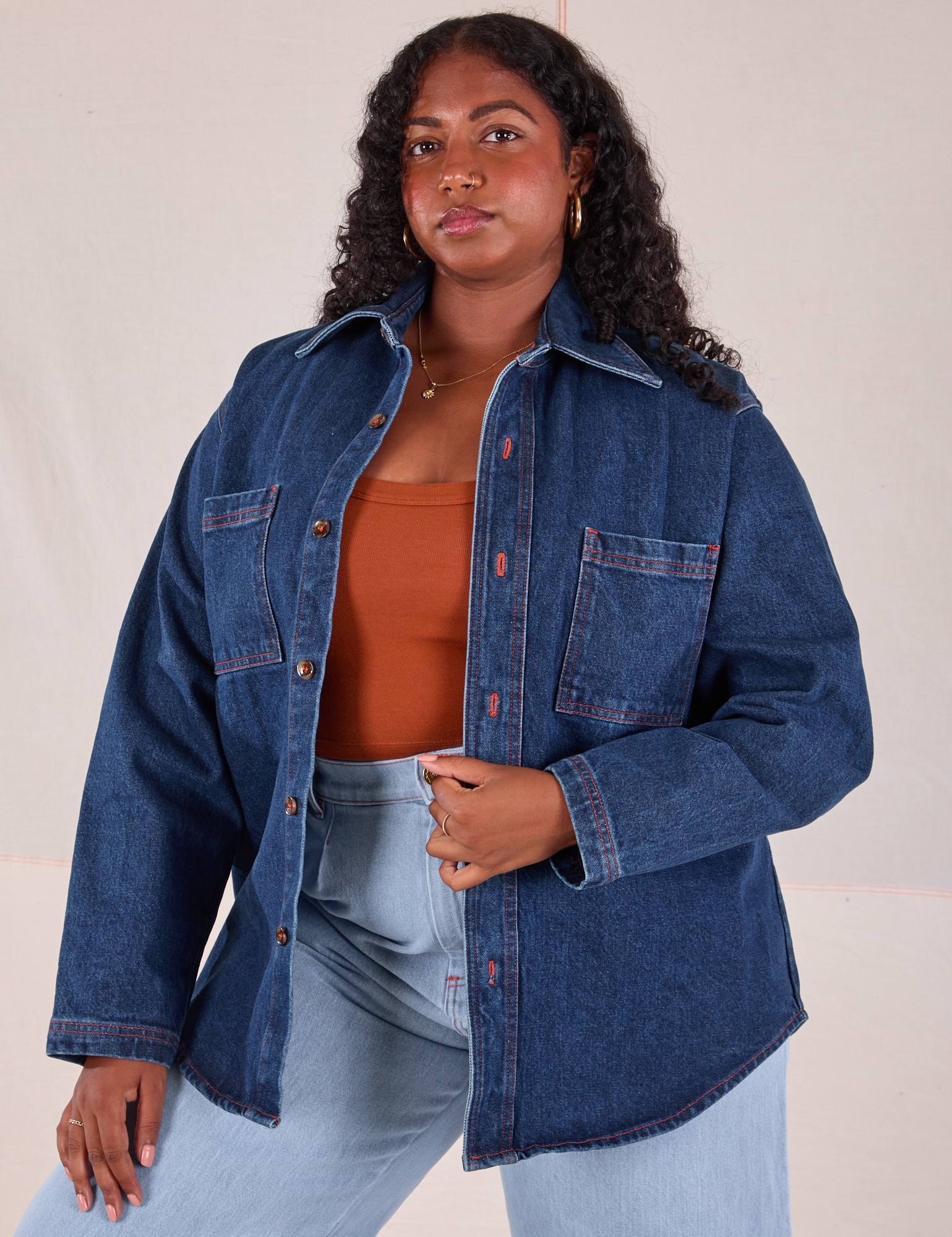 Meghna is 5&#39;7&quot; and wearing XS Denim Overshirt in Dark Wash with a burnt terracotta Cropped Tank underneath