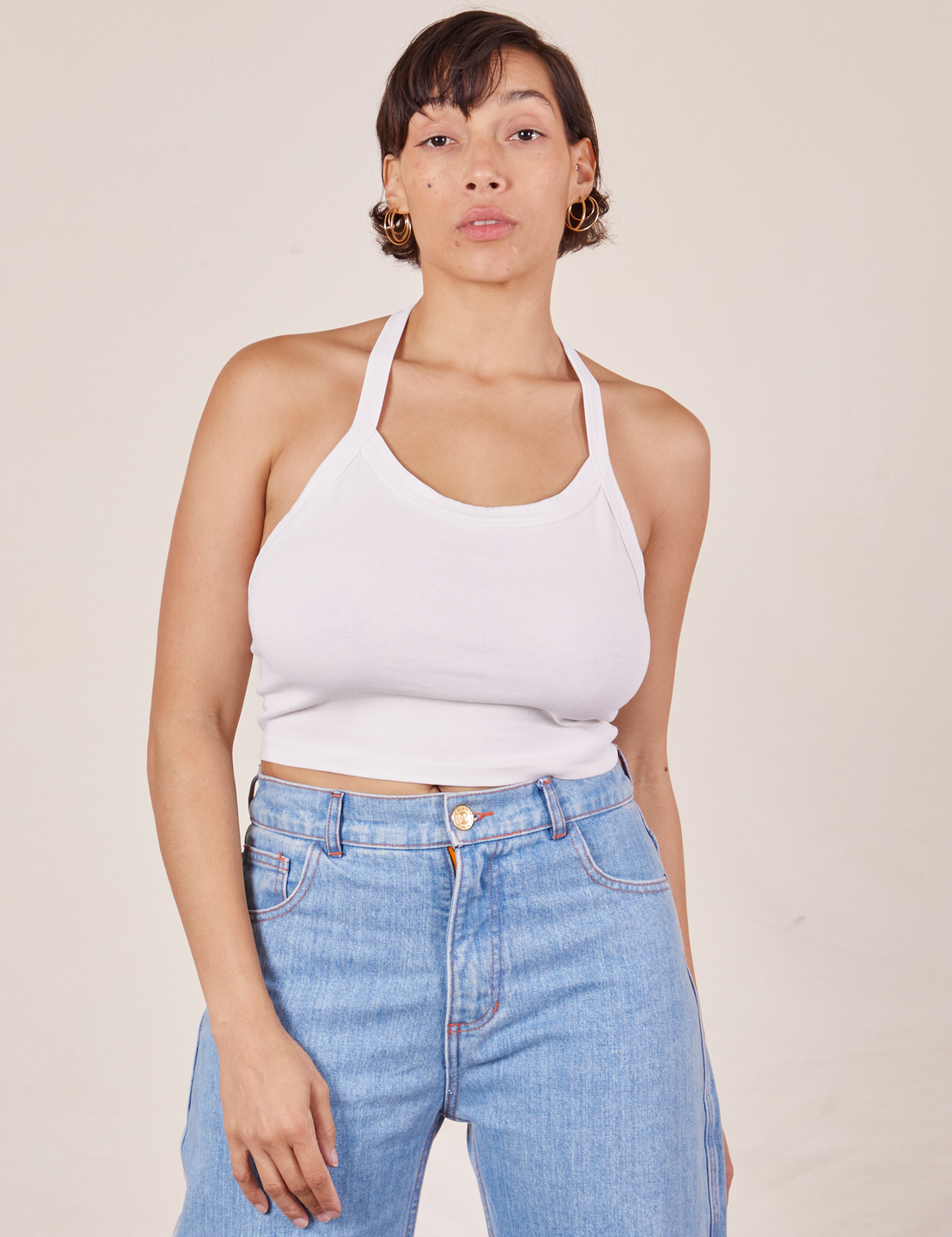 Tiara is 5'4" and wearing XS Halter Top in Vintage Off-White paired with light wash Sailor Jeans