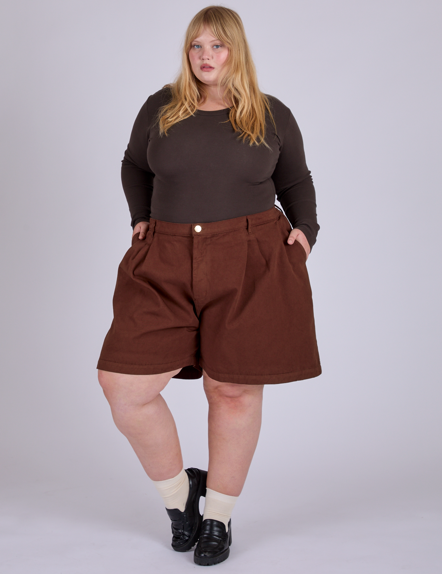 Juliet is wearing Pleated Trouser Shorts in Fudgesicle Brown and espresso brown Long Sleeve Baby Tee