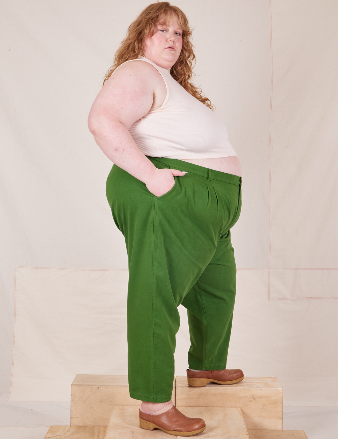 Side view of Heavyweight Trousers in Lawn Green and vintage off-white Sleeveless Turtleneck worn by Catie