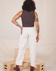 Back view of Heavyweight Trousers in Vintage Off-White and espresso brown Sleeveless Turtleneck worn by Jesse.