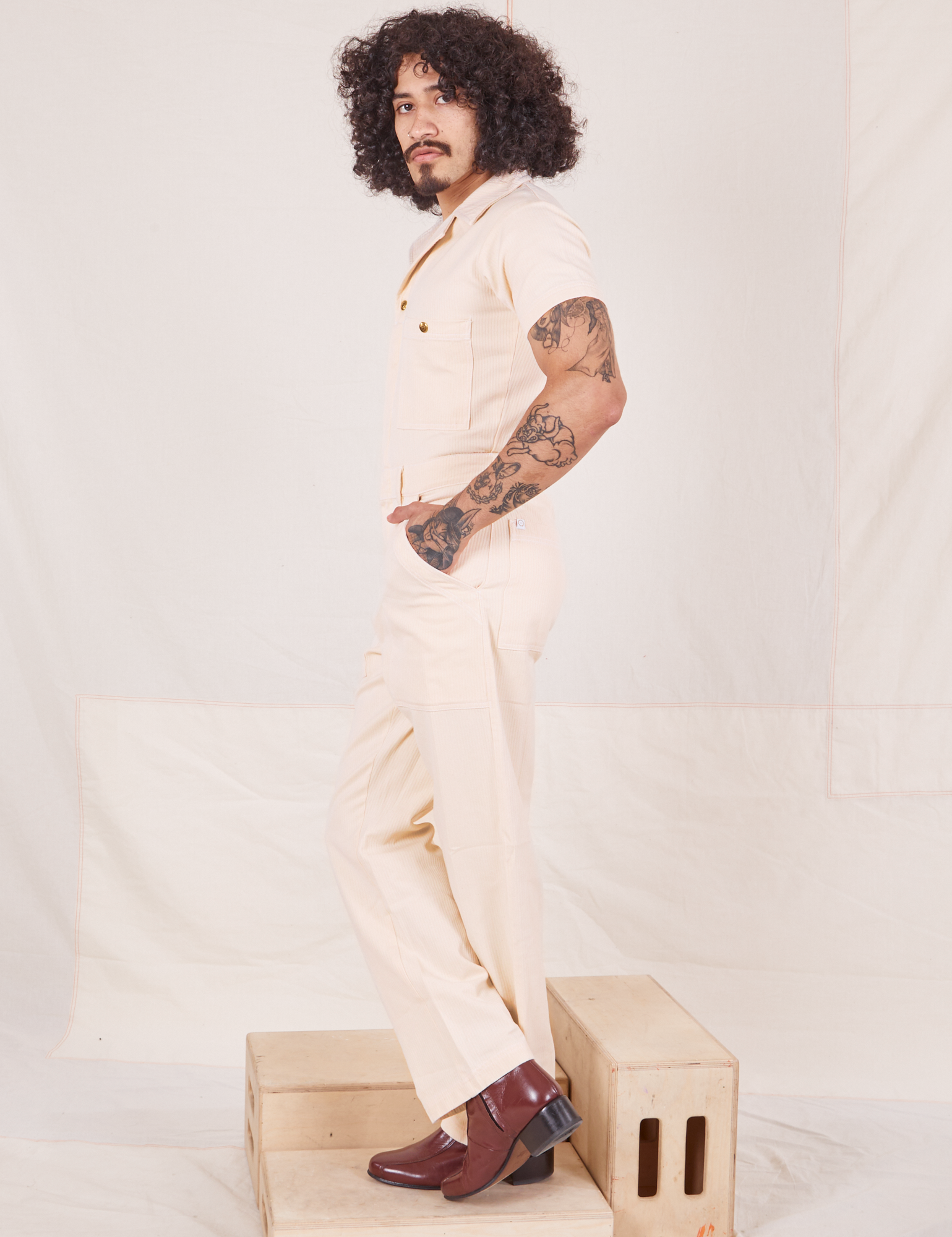 Side view of Heritage Short Sleeve Jumpsuit in Natural worn by Jesse