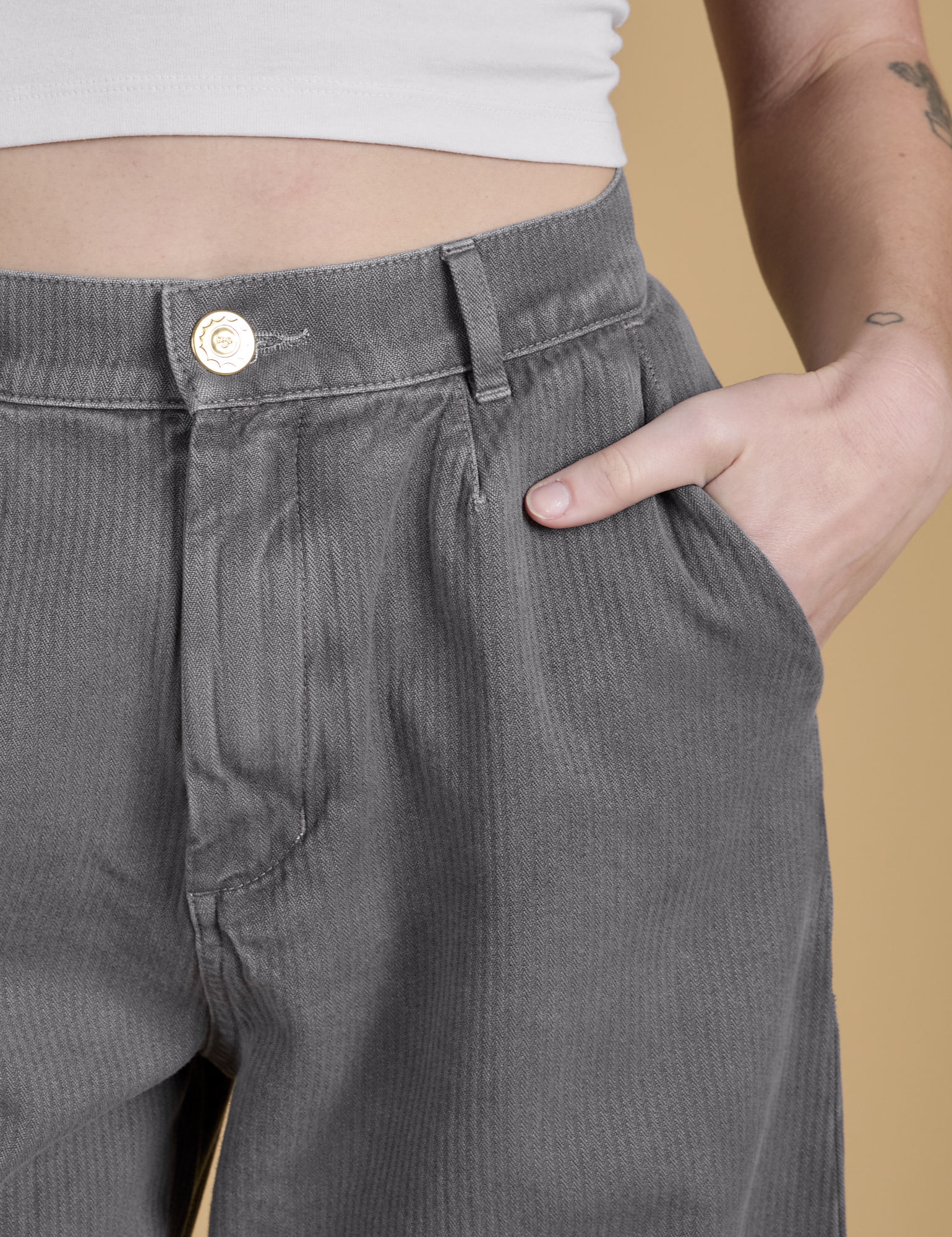 Close up of Alex&#39;s hand in the front pocket of Heritage Wide Leg Trousers in Washed Grey