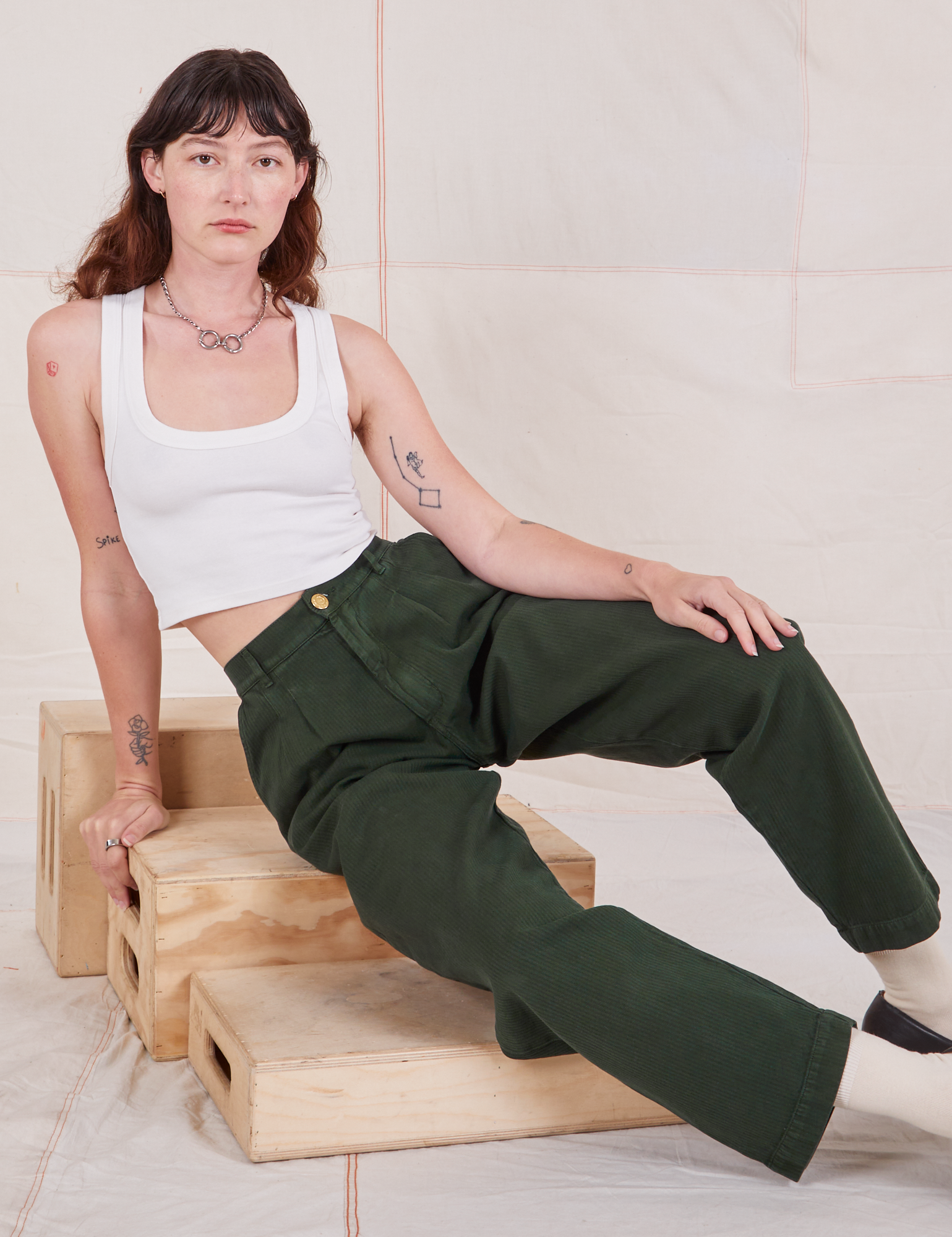 Alex is wearing Heritage Trousers in Swamp Green and vintage off-white Cropped Tank Top