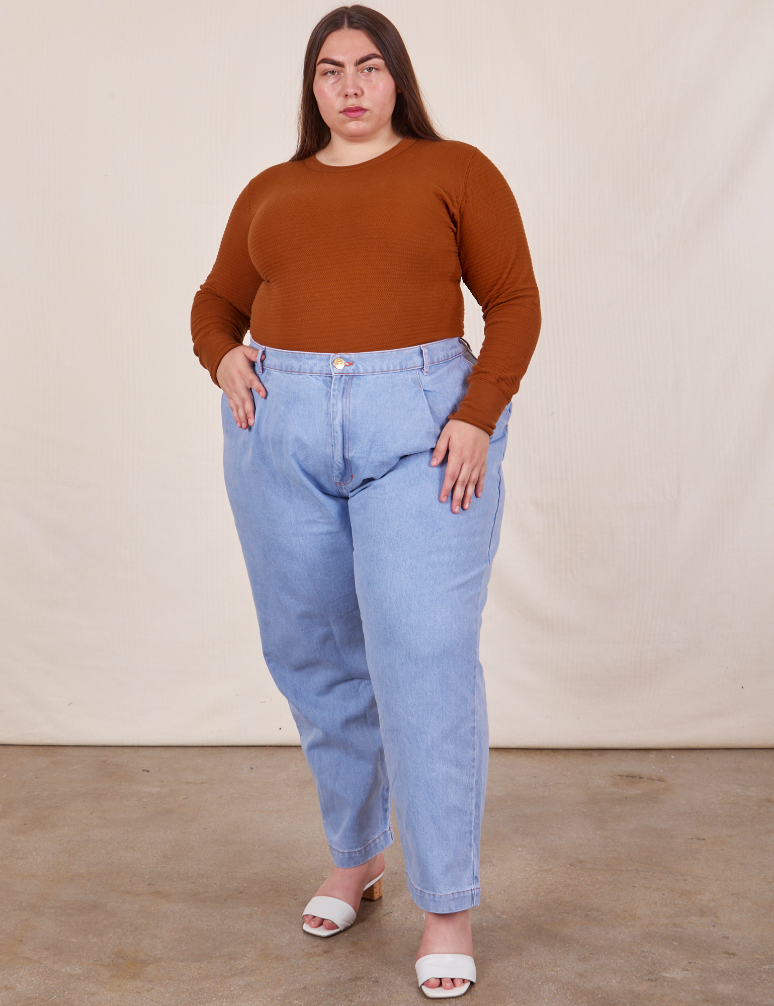 Marielena is wearing Honeycomb Thermal in Burnt Terracotta tucked into light wash Denim Trousers