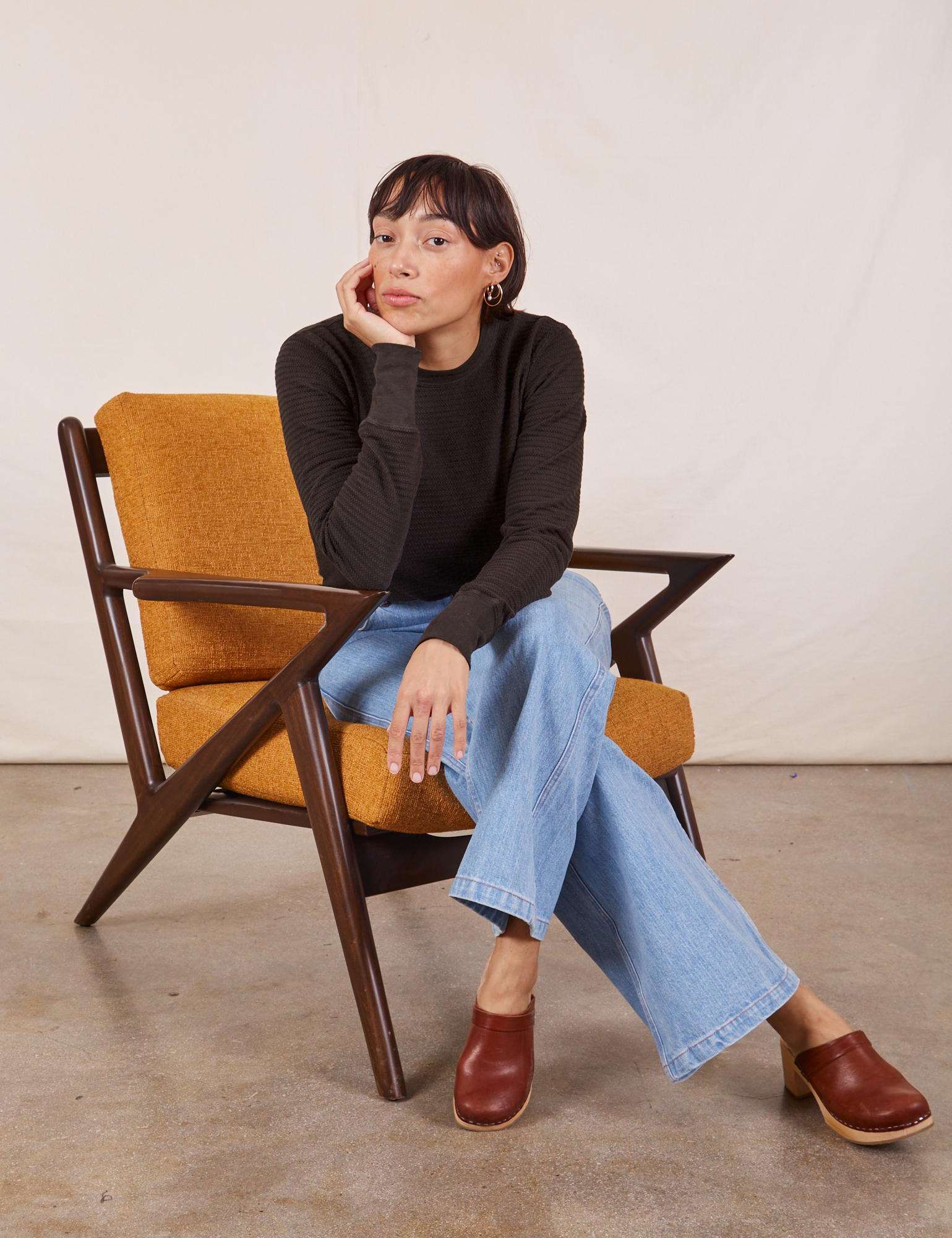 Tiara is wearing Honeycomb Thermal in Espresso Brown and sitting in a chair