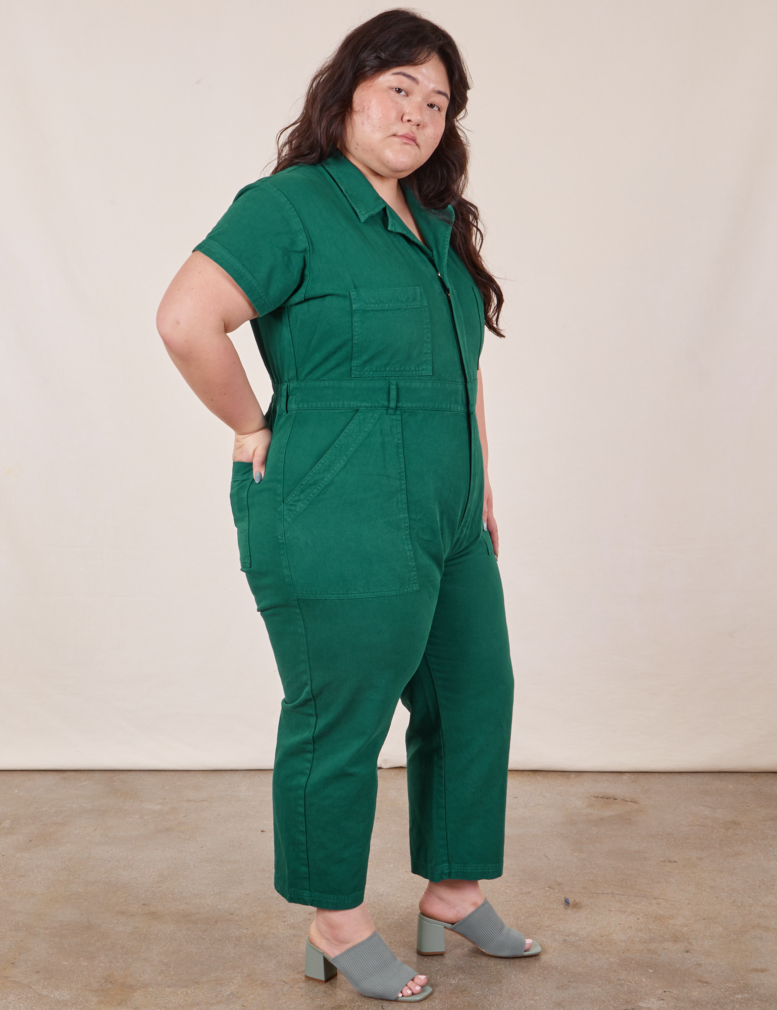 Side view of Petite Short Sleeve Jumpsuit in Hunter Green worn by Ashley