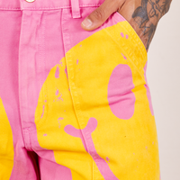 Front pocket close up of Icon Work Pants in Smilies. Jesse has their hand in the pocket.