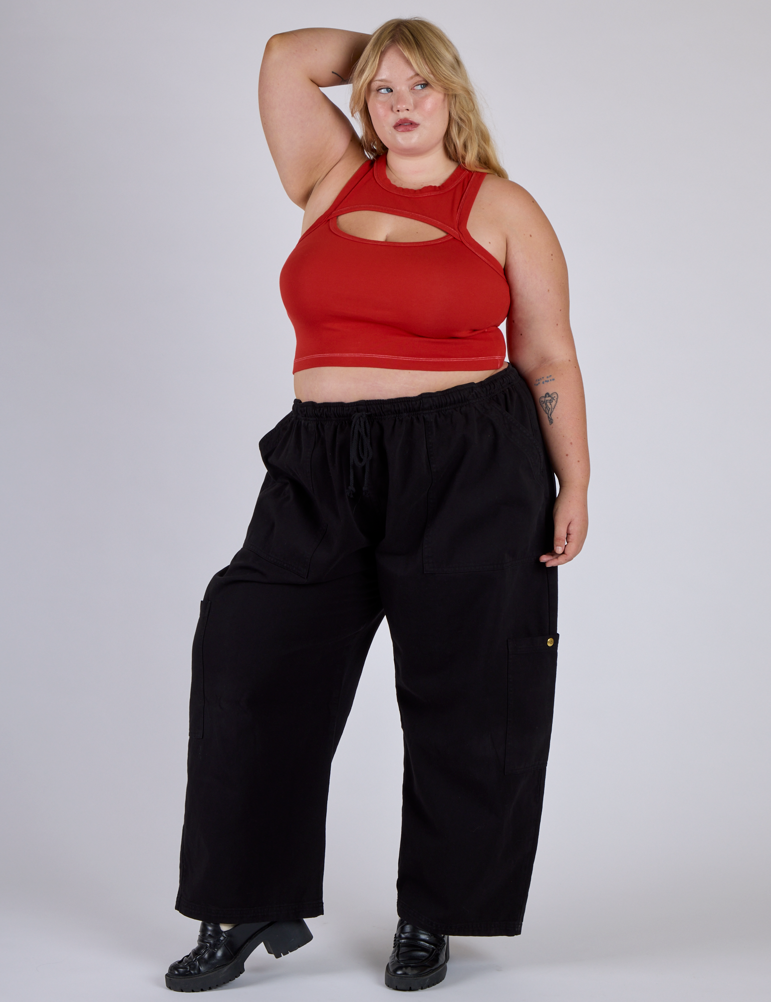 Juliet is wearing Porthole Tank in Mustang Red and black Drop Pocket Cargo Pants