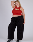 Juliet is wearing Porthole Tank in Mustang Red and black Drop Pocket Cargo Pants