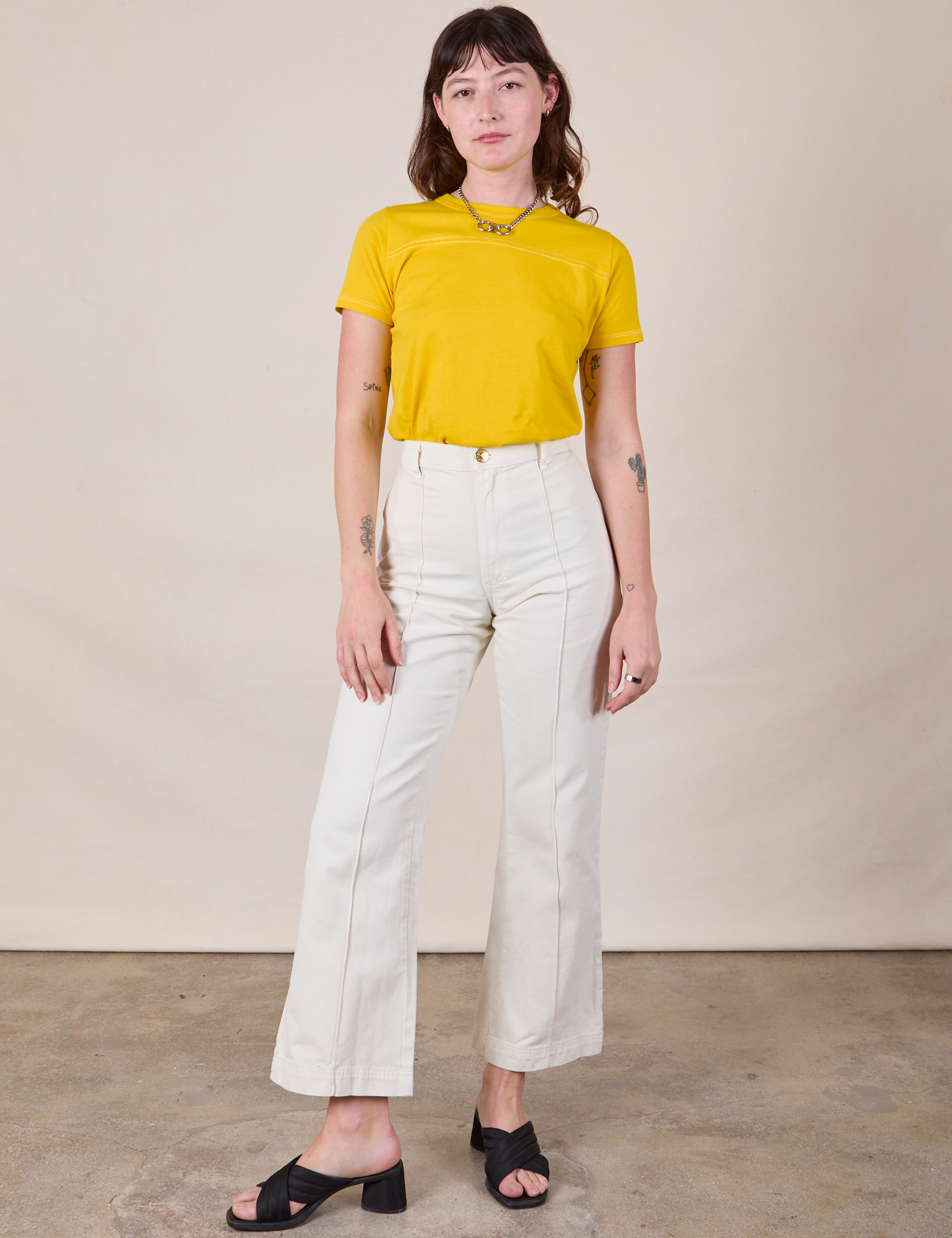 Alex is wearing JV Tee in Golden Yellow and vintage tee off-white Western Pants