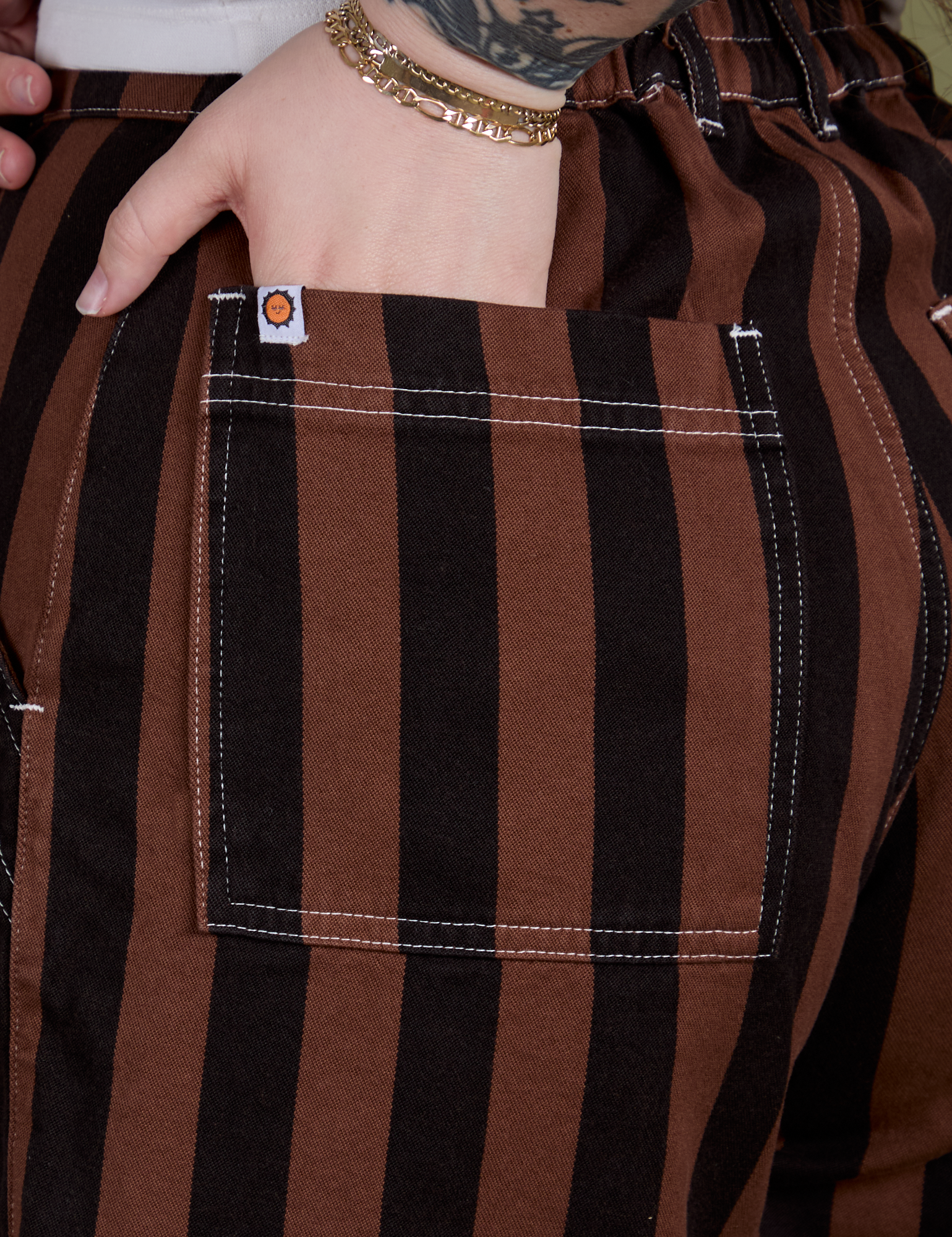 Close up of Sydney's hand in the back pocket of Longline Work Shorts in Fudgesicle Brown