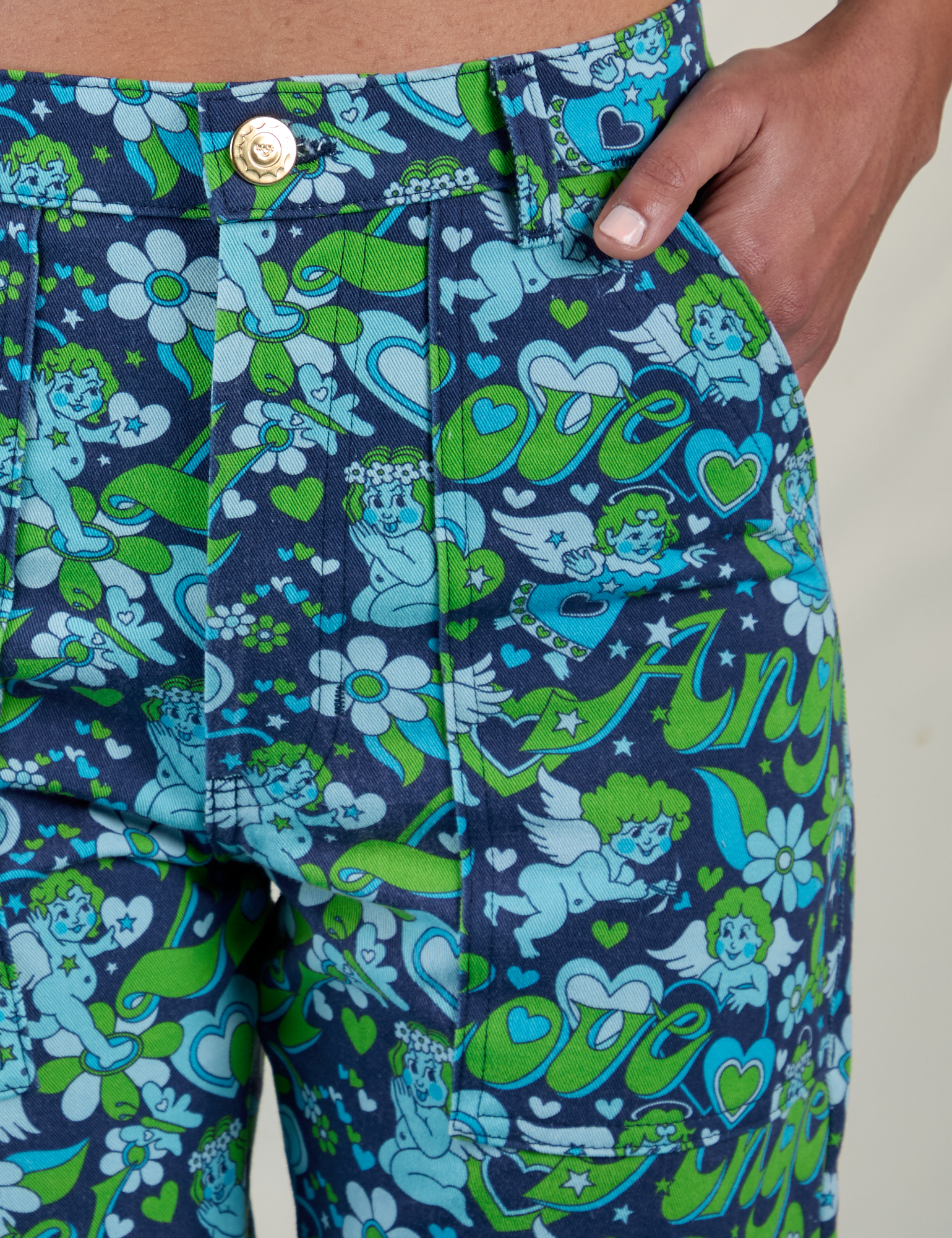 Close up of Shahana's hand in the front pocket of Work Pants in Angel Print