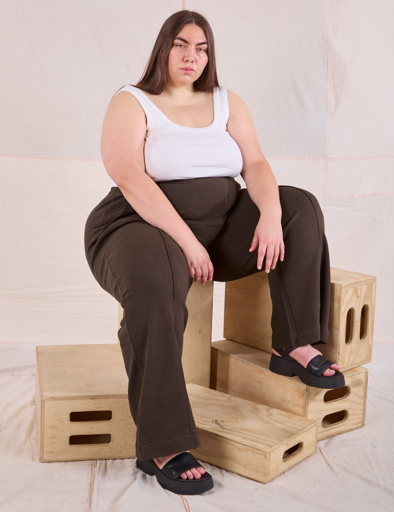 Marielena is sitting in her Easy Western Pants in Espresso Brown