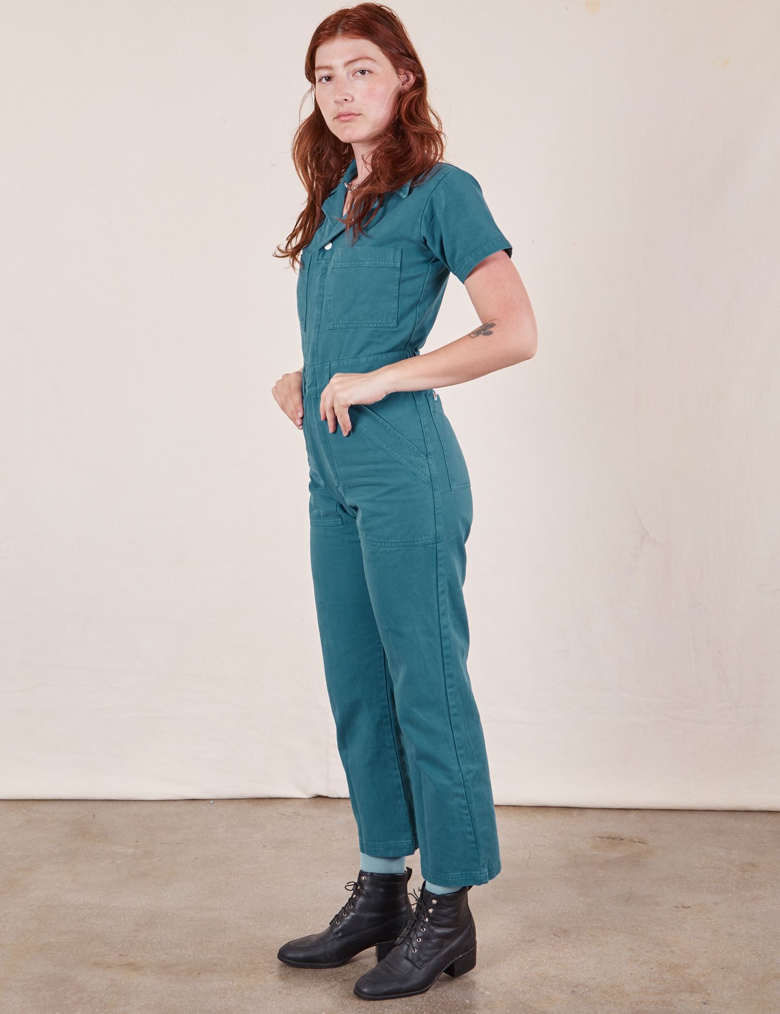 Side view of Short Sleeve Jumpsuit in Marine Blue worn by Alex
