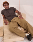 Issac is wearing Mid-Rise Pleated Trousers in Desert Brown and espresso brown Organic Vintage Tee