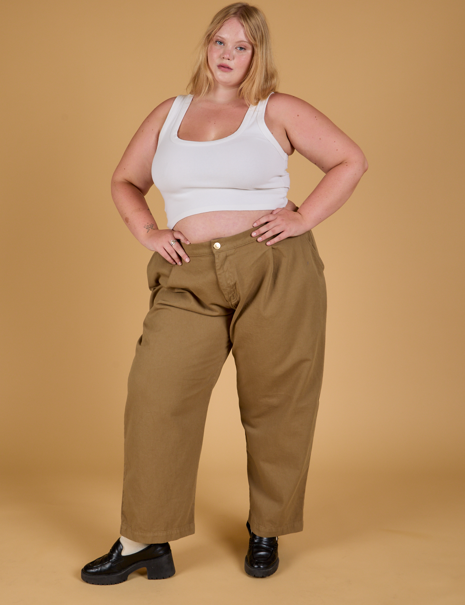 Juliet is wearing Baggy Mid-Rise Trousers in Desert Brown and vintage tee white Cropped Tank
