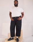 Elijah is 6'3" and wearing 1XL Mid-Rise Pleated Trousers in Basic Black paired with Organic Vintage Tee in vintage tee off-white