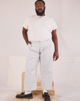 Elijah is 6'3" and wearing 1XL Mid-Rise Pleated Trousers in Stone White paired with Organic Vintage Tee in vintage tee off-white