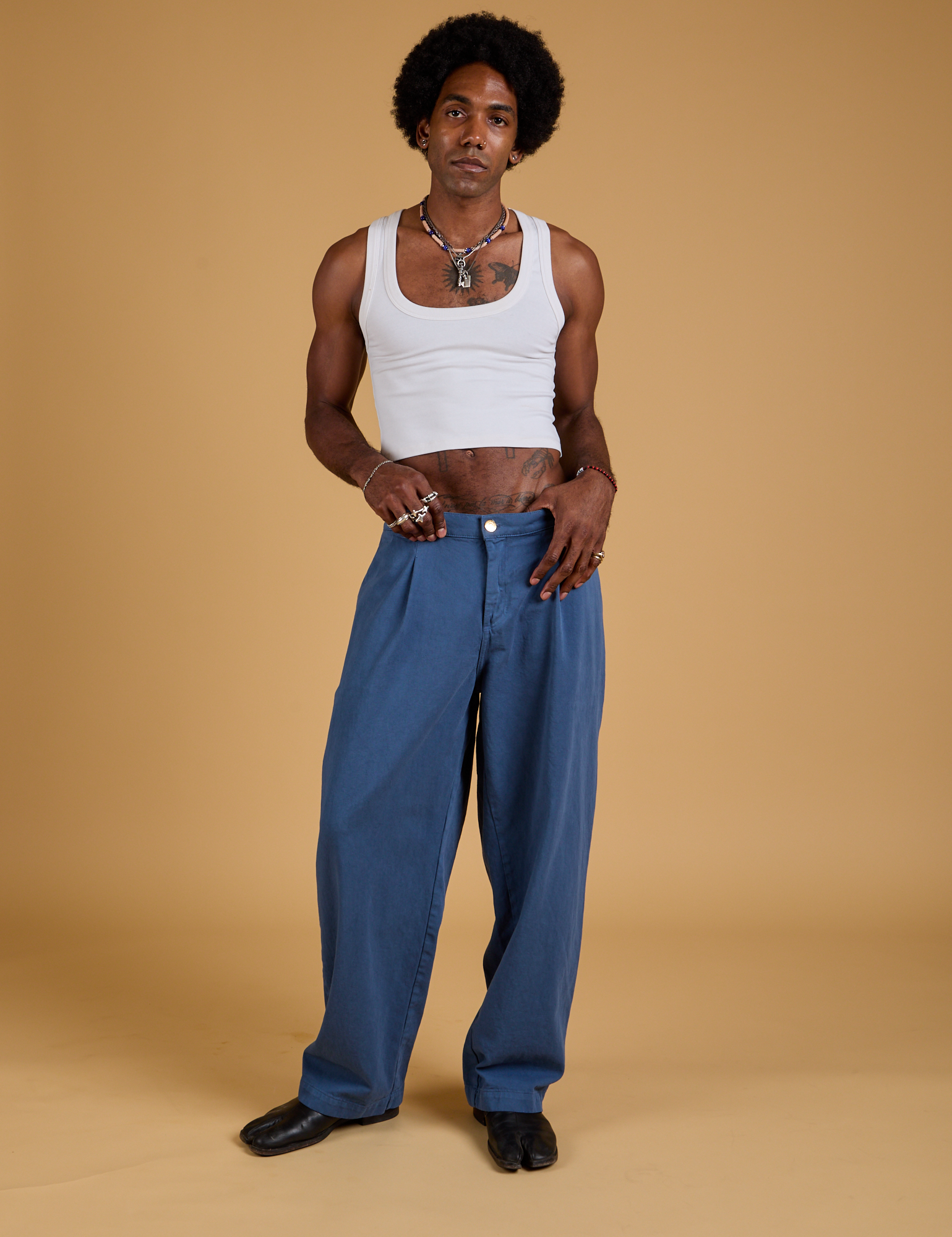 Jerrod is 6&#39;3&quot; and wearing M Baggy Mid-Rise Trousers in French Blue paired with a vintage tee white Cropped Tank