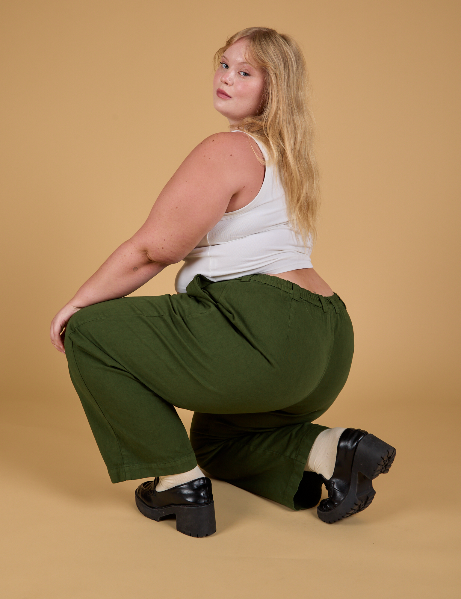 Angled back view of Baggy Mid-Rise Trousers in Evergreen on Juliet