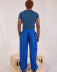 Back view of Mid-Rise Pleated Trousers in Royal Blue and lagoon Baby Tee on Issac