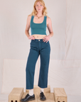 Margaret is 5'11" and wearing XS Mid-Rise Work Pants in Lagoon paired with marine blue Cropped Tank