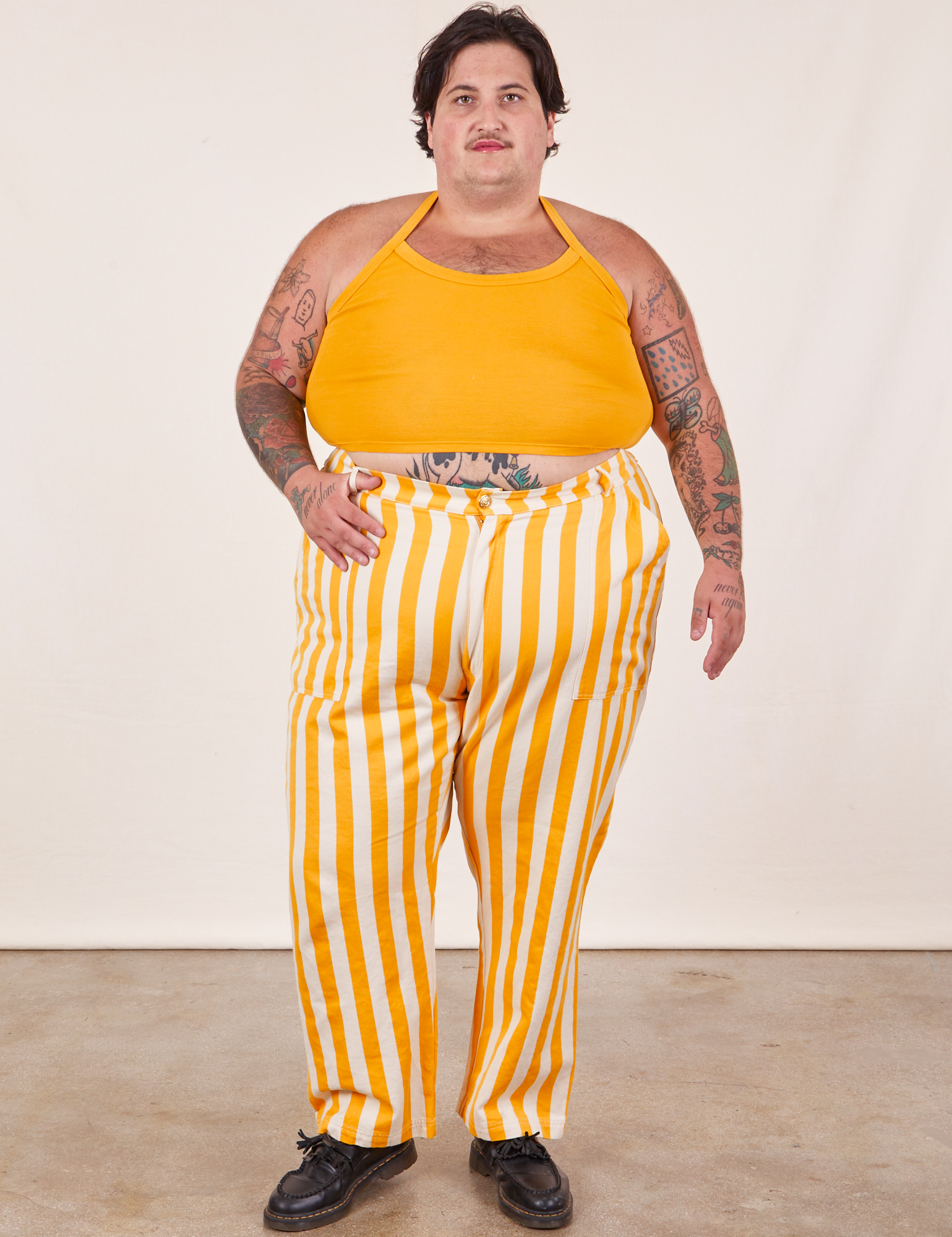 Sam is 5’10” and wearing 3XL Work Pants in Lemon Stripe mustard yellow Halter Top