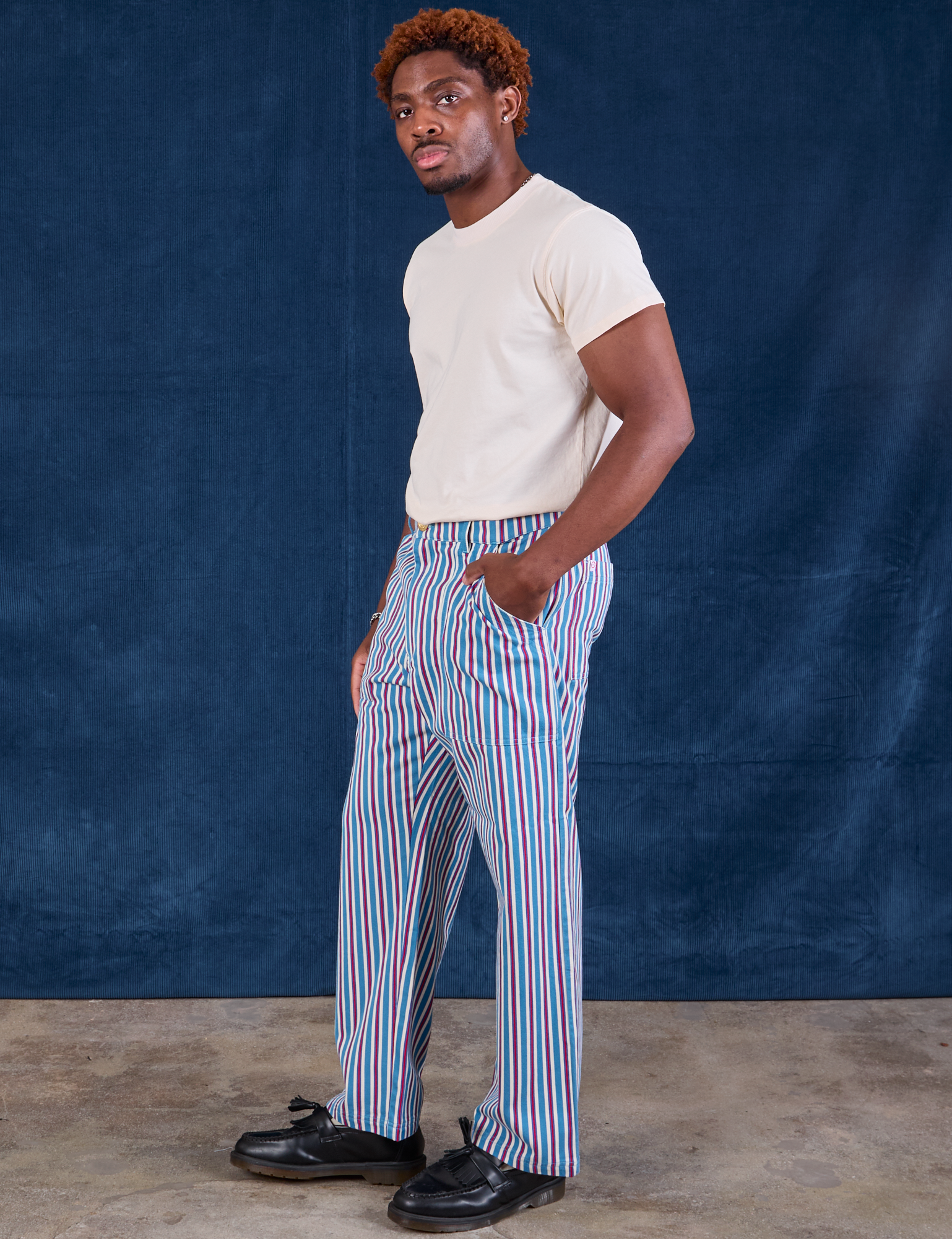 Side view of Stripe Work Pants in Blue Raspberry and Organic Vintage Tee in vintage tee off-white on Issac