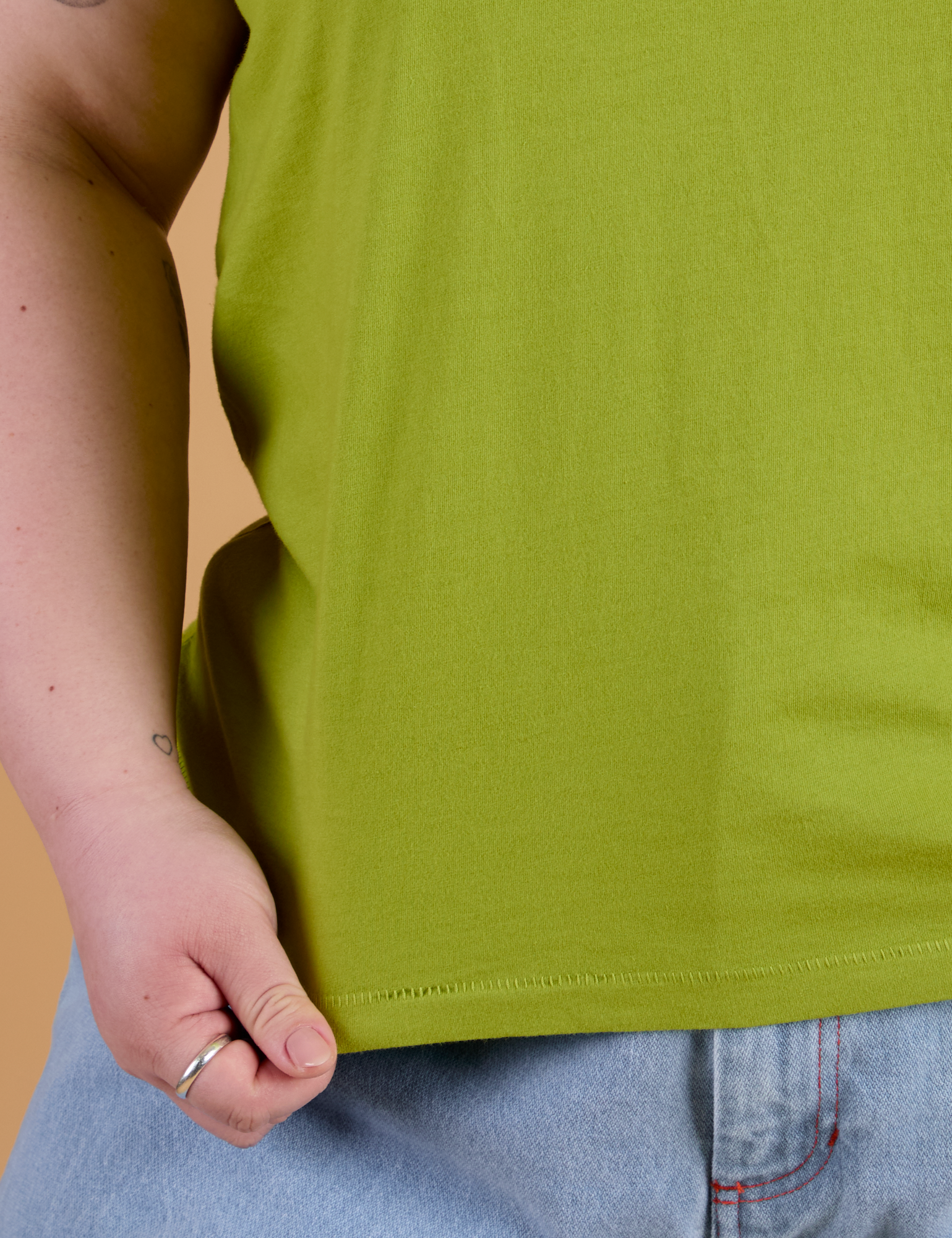 Organic Vintage Tee in Gross Green bottom close up with Ashley holding hem