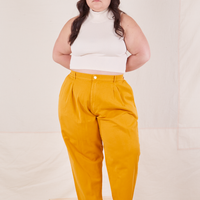 Ashley is 5'7" and wearing 1XL Petite Organic Trousers in Mustard Yellow paired with vintage off-white Sleeveless Essential Turtleneck