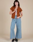 Alex is wearing Pantry Button-Up in Burnt Terracotta and light wash Indigo Wide Leg Trousers