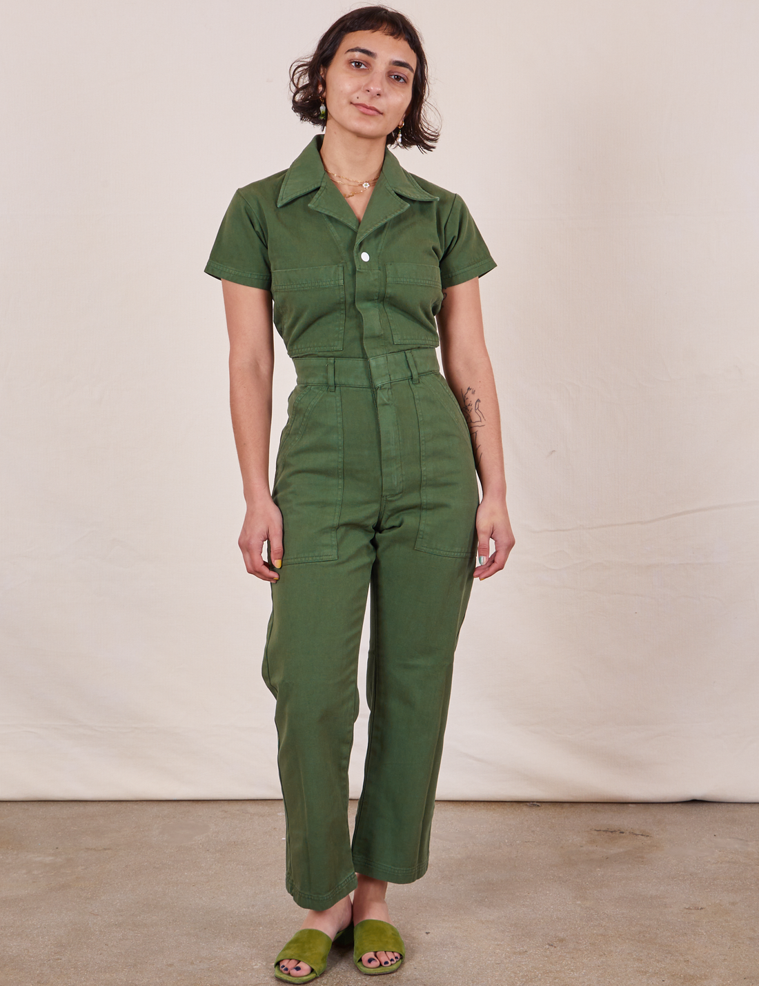 Soraya is 5’2” and wearing XXS Petite Short Sleeve Jumpsuit in Dark Emerald Green