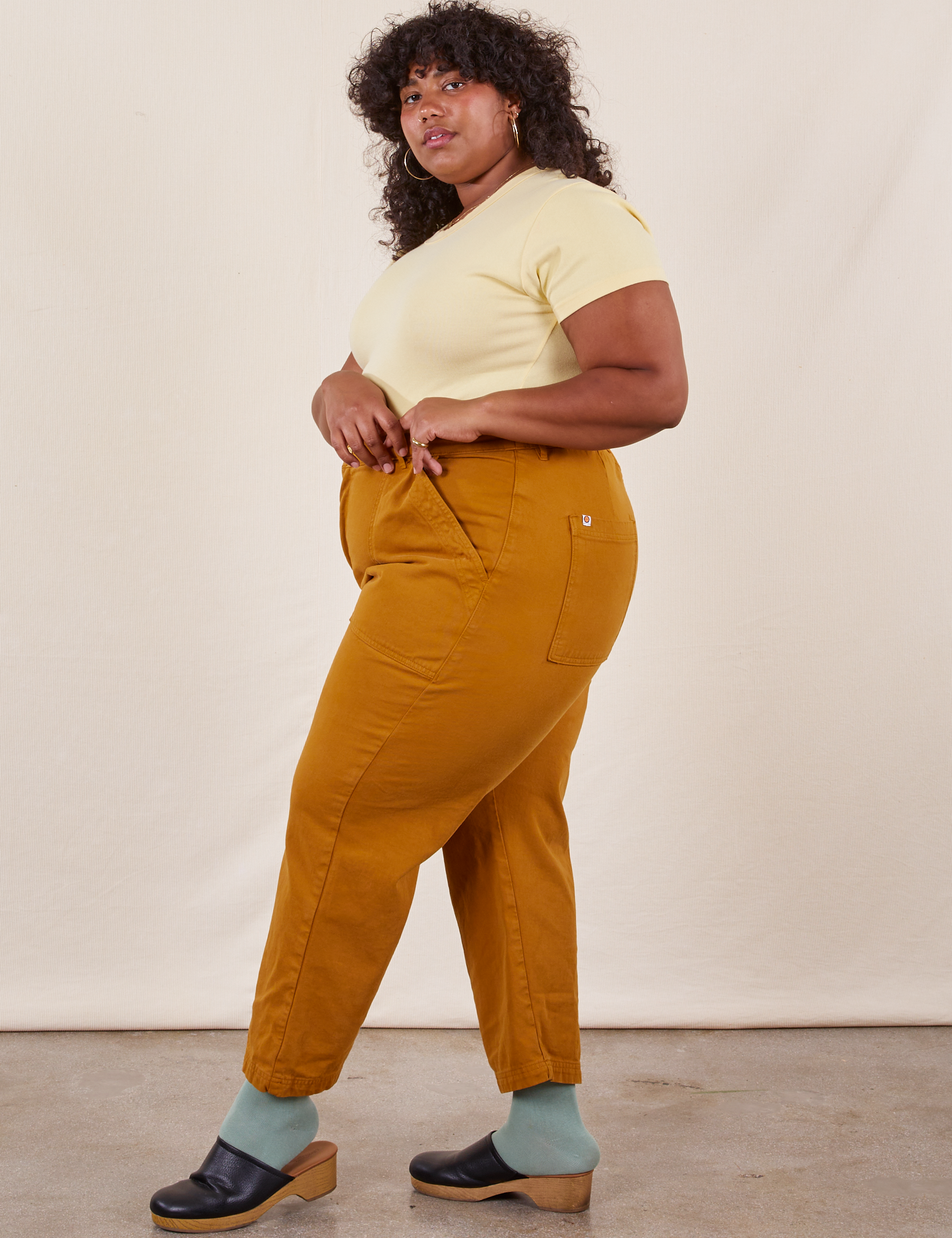 Work Pants in Spicy Mustard side view on Morgan wearing butter yellow baby Tee