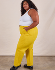 Side view of Work Pants in Golden Yellow and Cropped Tank in Vintage Tee Off-White on Morgan