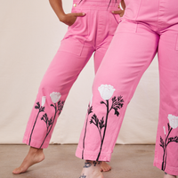 Gabi and Sydney are both wearing California Poppy Overalls in Bubblegum Pink. Both have their left legs kicked out a little and their hands in the pant pocket.