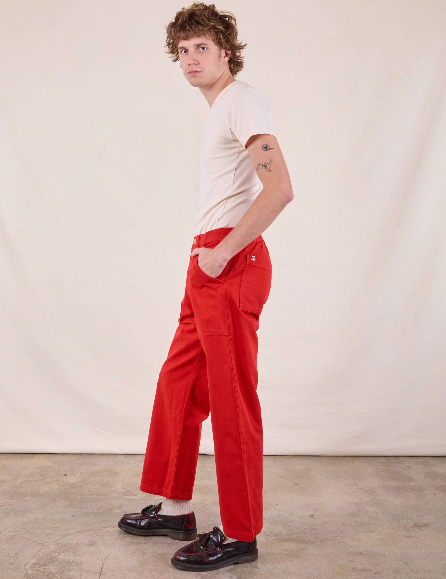 Side view of Work Pants in Mustang Red and Burly Tee in Vintage Tee Off-White