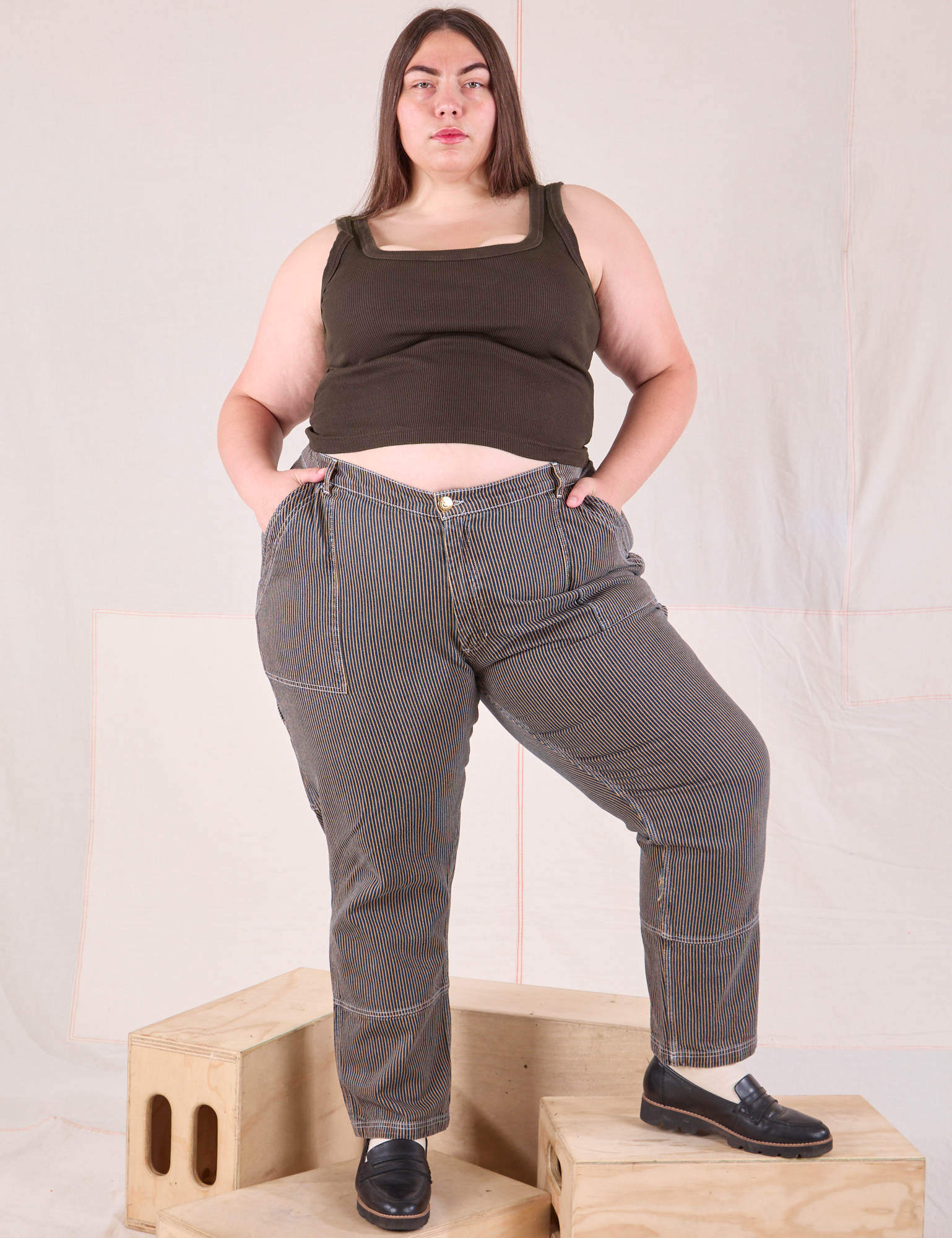 Marielena is 5&#39;8&quot; and wearing 2XL Railroad Carpenter Jeans in Vintage Tan paired with espresso brown Square Neck Tank