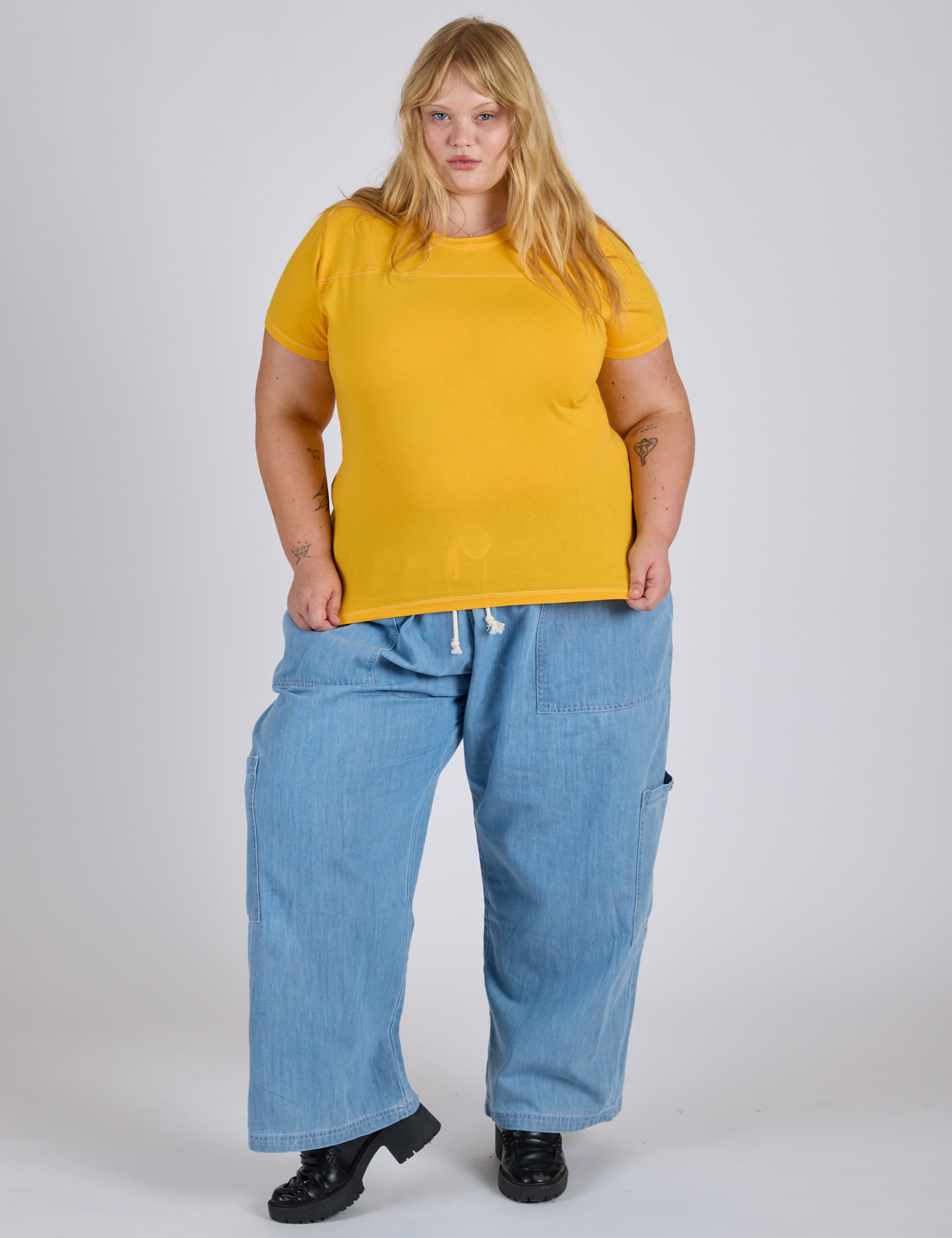 Juliet is 5’7” and wearing L Jr. Varsity Tee in Sunshine Yellow paired with light wash Denim Drop Pocket Pants