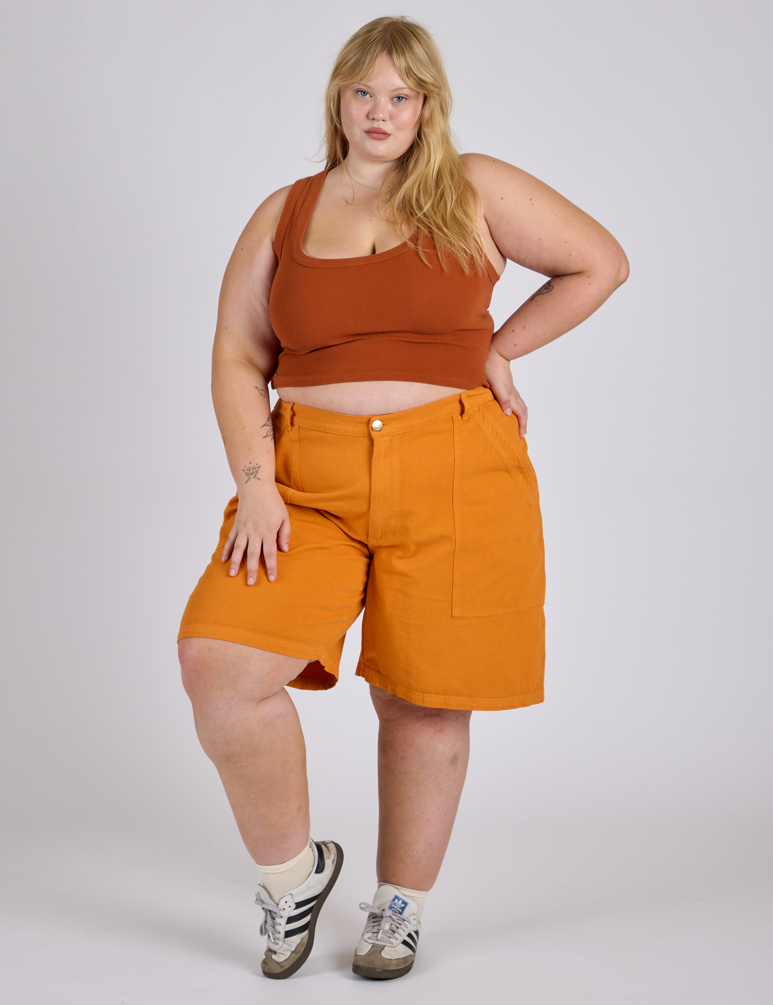 Juliet is 5’7” and wearing 2XL Longline Work Shorts in Creamsicle Orange paired with burnt terracotta Cropped Tank