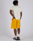 Angled back view of Longline Work Shorts in Sunshine Yellow and Burly Tee in Vintage Tee White