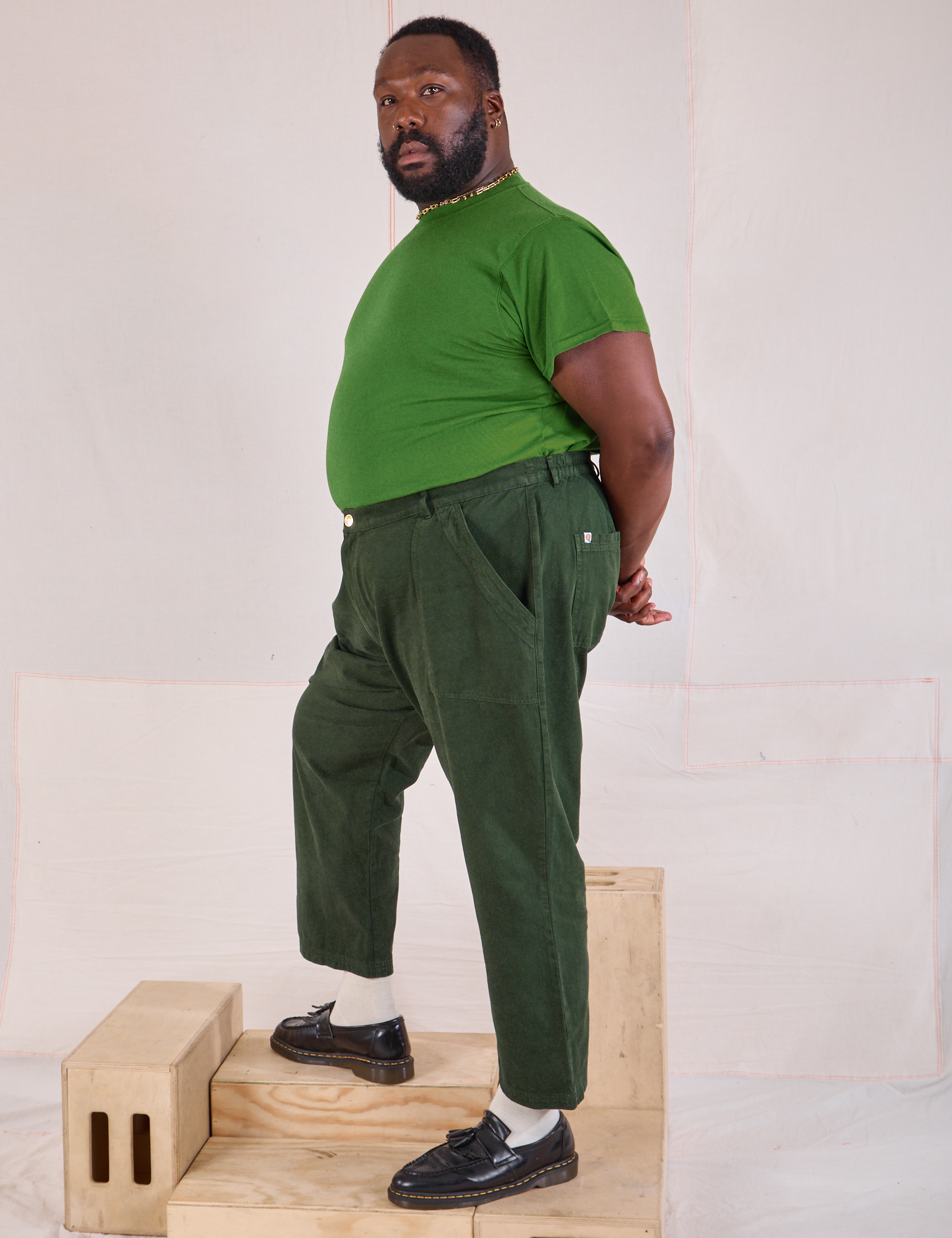 Side view of Mid-Rise Work Pants in Swamp Green and lawn green Organic Vintage Tee on Elijah