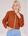 Madeline is wearing a zipped up Ricky Jacket in Burnt Terracotta
