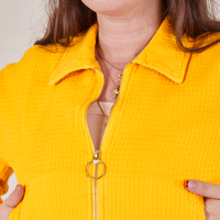 Front cloes up of Ricky Jacket in Sunshine Yellow. Brass circle pull tab on zipper.