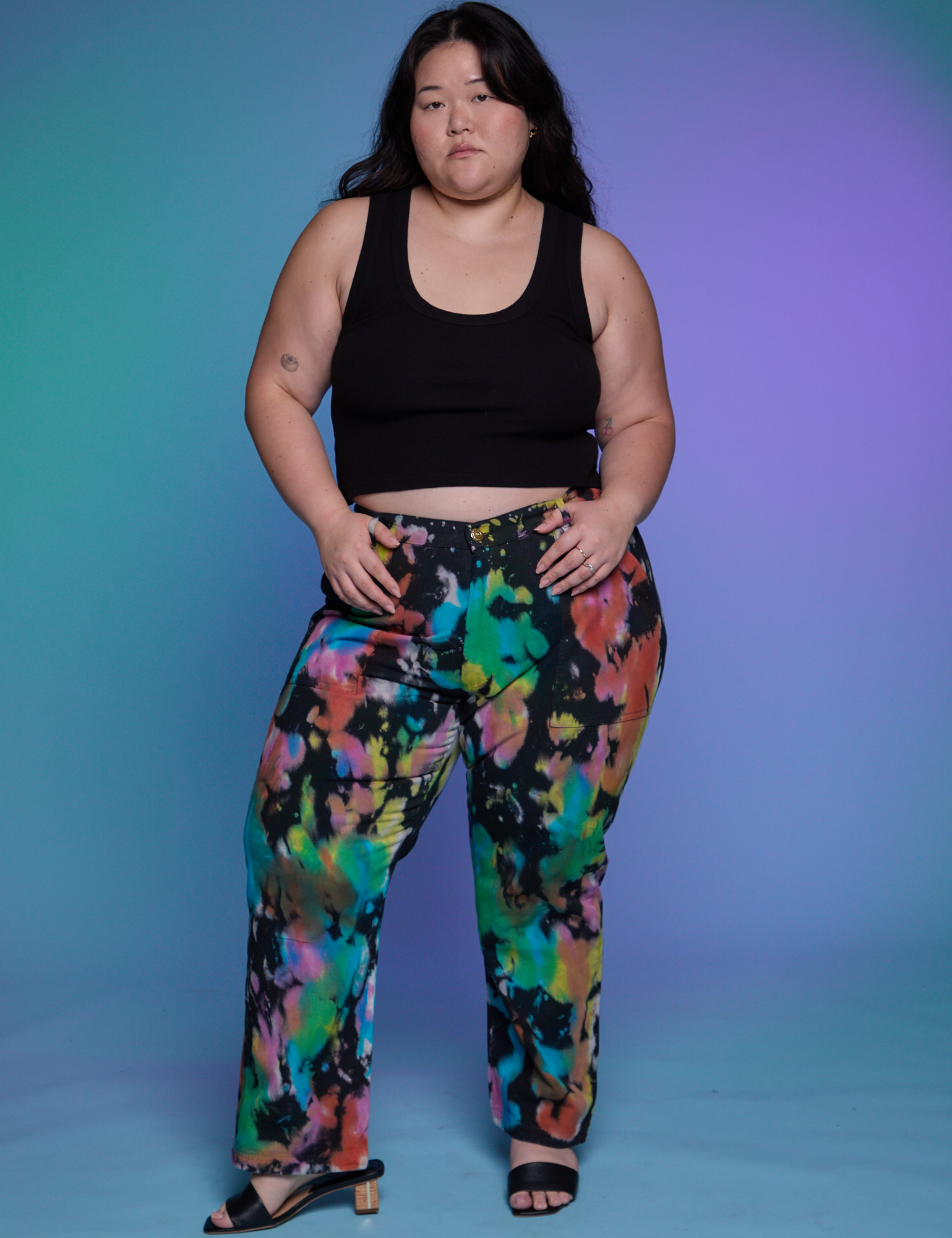 Ashley is 5&#39;7&quot; and wearing 1XL Work Pants in Rainbow Magic Waters paired with a black Cropped Tank