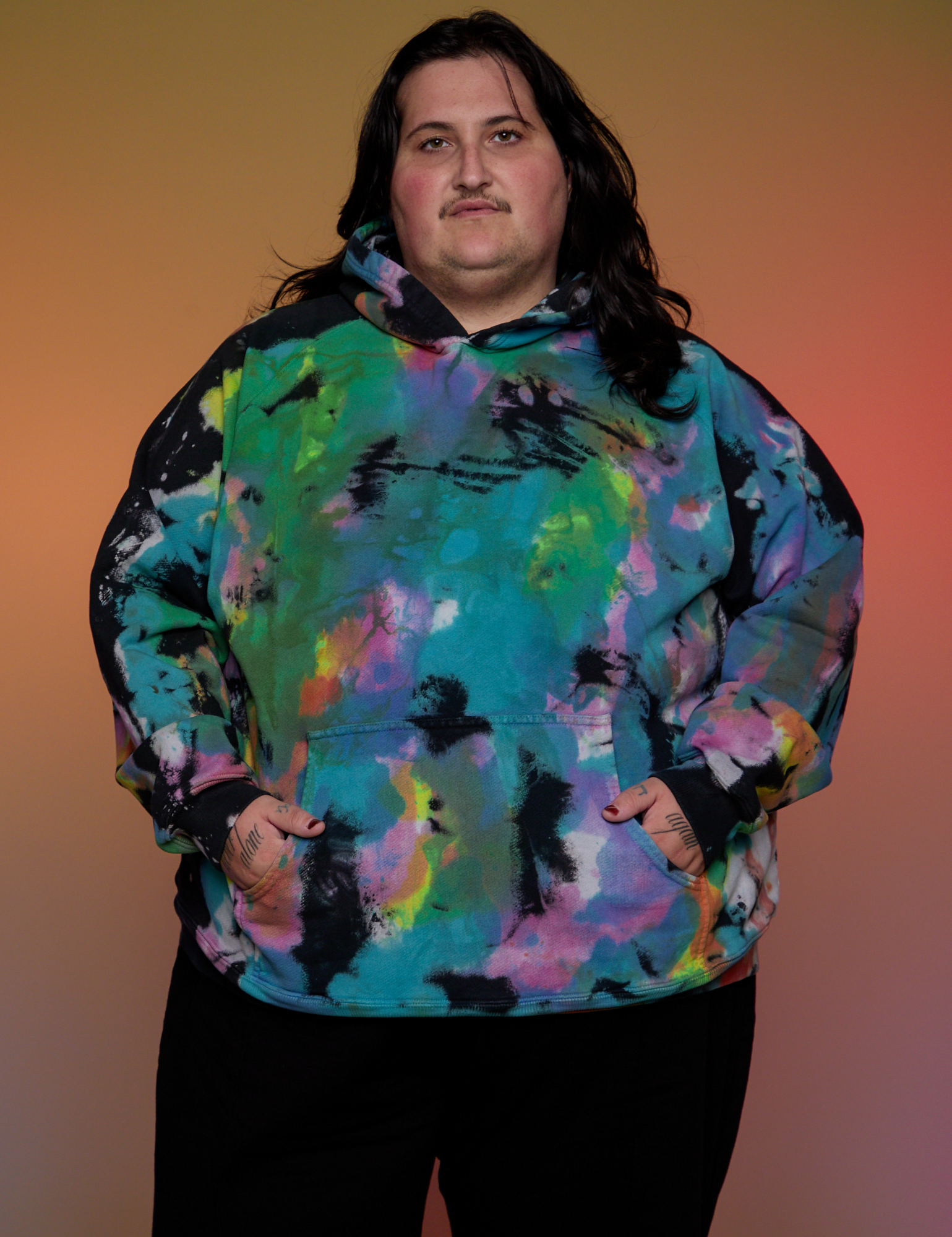 Sam is 5’10” and wearing 1XL Oversized Hoodie in Rainbow Magic Waters